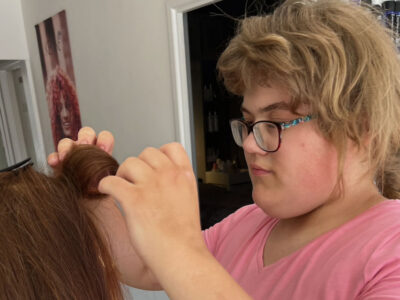 Lily on her work experience rolling up the hair of a mannequin