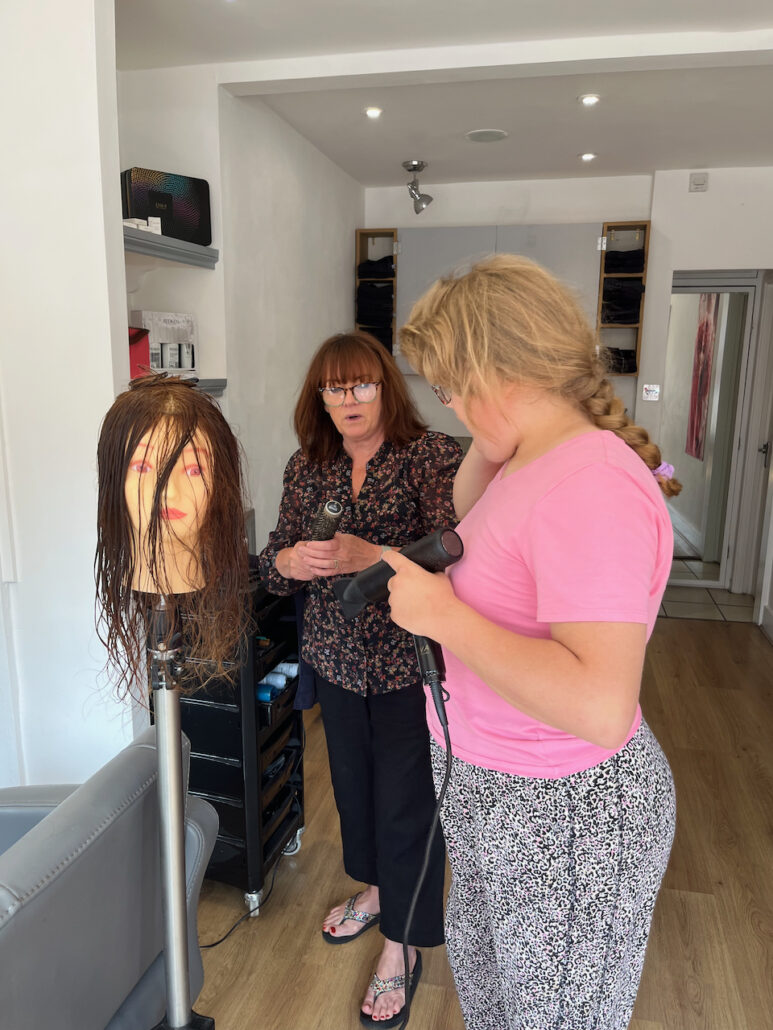 Lily blow drying the mannequin